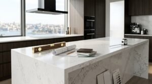 Calacatta marble waterfall kitchen island in a luxury high-rise Sydney apartment featuring a brass spirit level, architectural blueprint roll, timber and stone sample blocks, and a measuring tape overlooking a harbour skyline view.