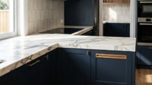 Navy blue timber shaker kitchen cabinetry with dovetail drawer construction, slimline metal pulls, and integrated wall ovens beneath open wood display shelving.