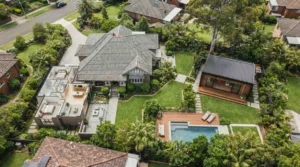 Aerial view of a modern granny flat positioned in a spacious landscaped backyard beside the main family home