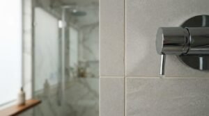 Cracked bathroom wall tile near shower control valve showing potential water damage issue