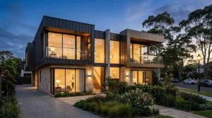 Modern luxury duplex home with contemporary architecture, landscaped garden, and illuminated interiors in an upscale residential neighborhood at dusk
