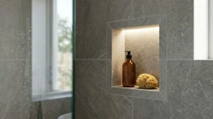 Modern tiled shower wall featuring a recessed storage niche with integrated lighting, holding a soap dispenser and natural sponge