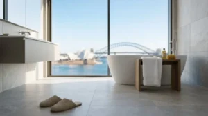 Modern minimalist bathroom with a freestanding tub, floor-to-ceiling window, and waterfront city skyline view