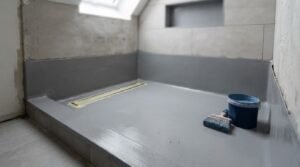 Waterproofed shower base with a linear drain during bathroom renovation.