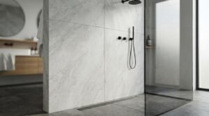 Large-format light grey marble-look porcelain wall tiles in a walk-in shower with matte black fixtures and a linear floor drain
