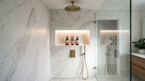 Walk-in shower featuring large-format Calacatta marble wall tiles, LED-backlit niche, brushed brass hardware, and a linear floor drain