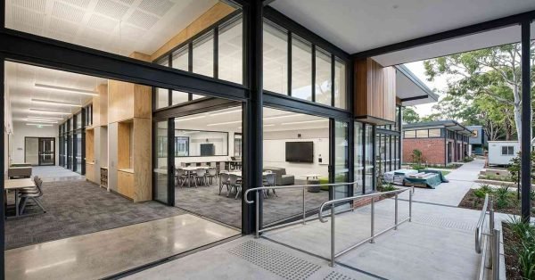 Modern school campus renovation featuring glass-walled classrooms, collaborative learning spaces, accessible pathways, contemporary timber finishes, and seamless indoor-outdoor educational environments.