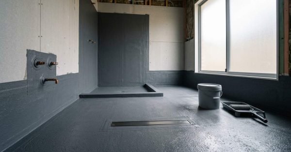 Bathroom waterproofing in progress during a Sydney renovation, showing a professionally applied waterproof membrane across the shower and bathroom floor before tiling.