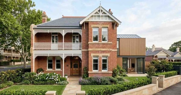 Beautifully restored heritage-listed brick home in Sydney featuring preserved Victorian architectural details, ornate lacework verandas, and a contemporary rear extension, demonstrating how modern renovations can successfully integrate with heritage homes while complying with conservation guidelines and preserving original character.