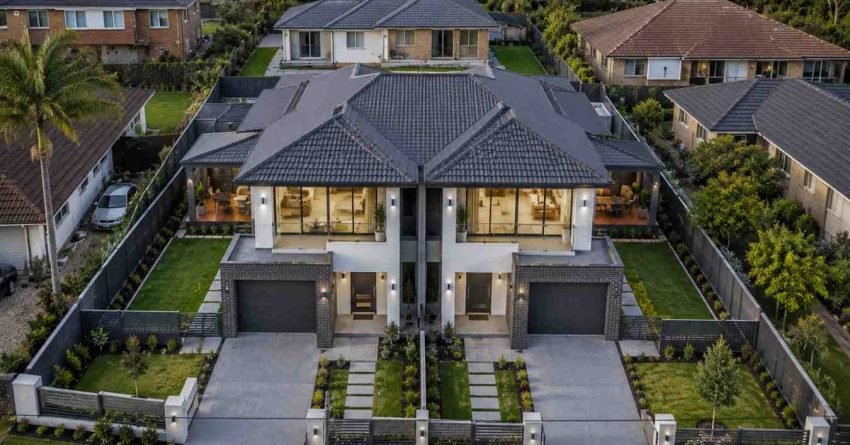 Aerial view of a newly completed Sydney duplex development featuring two attached modern residences with separate entrances, garages, private outdoor spaces, and contemporary architecture on a suburban residential block